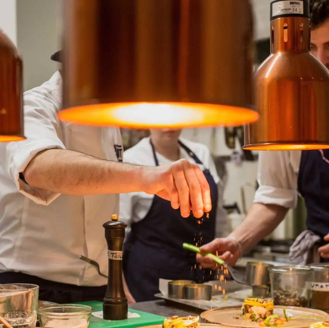 A Chef Sprinkling on a Plate of Food on a Plate